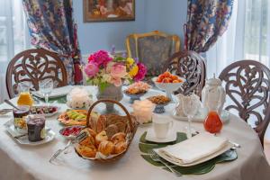 - une table avec des produits pour le petit-déjeuner et des fleurs dans l'établissement Maison d'hôtes de charme La Rose de Ducey près du Mont Saint Michel, à Ducey
