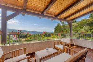 un patio con sillas y mesas y un balcón con vistas. en Kuća za odmor Suzi, en Kornić