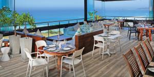 a restaurant with tables and chairs and a view of the ocean at Brenton Haven Beachfront Resort in Knysna