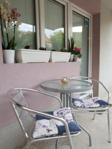 a glass table and two chairs sitting on a balcony at Vila Stefanovic in Soko Banja