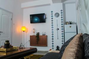 a living room with a couch and a tv on a wall at Nirvana Apartament in Bucharest