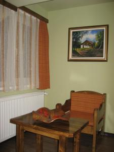 ein Esszimmer mit einem Tisch und einem Gemälde an der Wand in der Unterkunft Pensiunea Igazland *** in Dumbrava