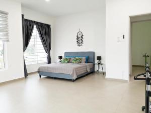 ein Schlafzimmer mit einem blauen Bett in einem weißen Zimmer in der Unterkunft Urban Space in Malakka