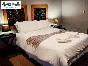 a bedroom with a large bed with two towels on it at Mont d'Or Monte Bello Estate in Bloemfontein