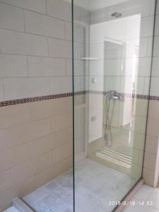 a shower with a glass door in a bathroom at Casa Prifti in Vlorë