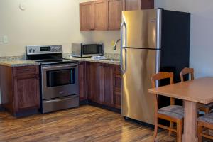 a kitchen with a stove, refrigerator, microwave and a table at Aspen Village in Waterton Park