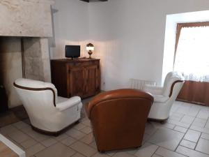 a living room with two chairs and a television at Le Bolet in Flaujac-Gare