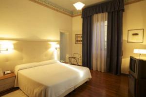 Deco Hotel في بيروجيا: غرفه فندقيه سرير وتلفزيون