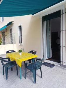 ein gelber Tisch und Stühle auf einer Terrasse in der Unterkunft Rapallina in Rapallo