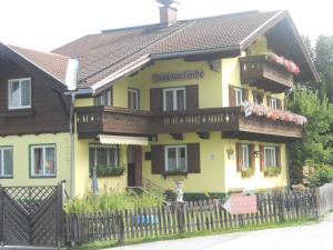 a yellow house with a wooden fence in front of it at Haus zur Linde in Wagrain