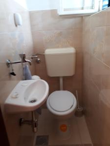 ein kleines Bad mit WC und Waschbecken in der Unterkunft Apartmani Neda in Trogir