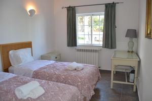 a room with two beds and a desk and a window at Palm Bay Apartment in Luz