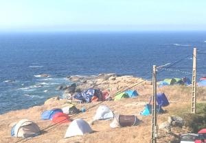 a group of tents on a cliff near the ocean at Apartamento Xardin in Muxia