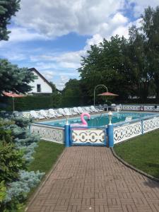 a swimming pool with a pink flamingo on a fence at Hotel Wegis Garni in Bermatingen