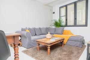 ein Wohnzimmer mit einem grauen Sofa und einem Couchtisch in der Unterkunft Home 12 les Vignes in Châteauneuf-du-Pape