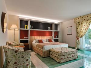 a hotel room with a bed and a chair at Hotel Hermitage in Forte dei Marmi