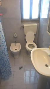 een witte badkamer met een toilet en een wastafel bij numero uno in Lido di Jesolo