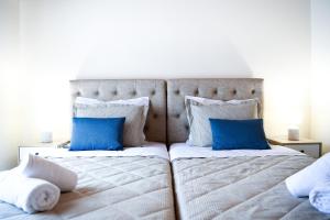 a bedroom with two beds with blue pillows at Anemi Superior Deluxe Suite in Kolios