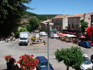 una città con auto parcheggiate in un parcheggio di Hotel Restaurant La Calade a Octon