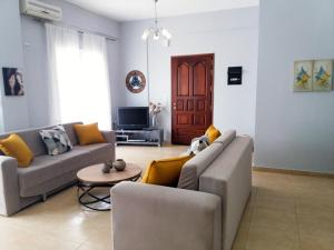 uma sala de estar com dois sofás e uma mesa em Lovely View Apartments em Himare