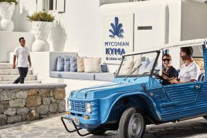 a blue pickup truck parked in front of a building at Myconian Kyma - Design Hotels in Mikonos