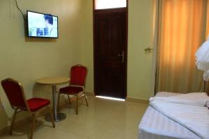 a room with a table and two chairs and a tv at Fort Breeze Hotel in Fort Portal