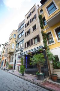 a building on a street with potted plants on it at T-Square Residence in Istanbul