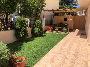 a backyard with green grass and plants and a fence at Artemis Apartments in Lefkada