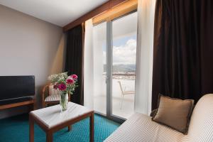 a hotel room with a vase of flowers on a table at Hotel Z Palace & Congress Center in Xanthi