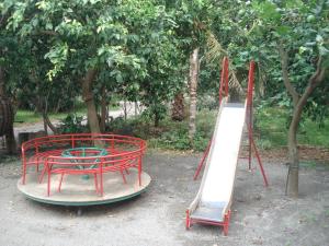 a playground with a red table and a slide at Agriturismo La Grevillea in Riposto