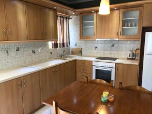 a kitchen with wooden cabinets and a wooden table at Artemis Apartments in Lefkada