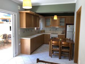 a kitchen with wooden cabinets and a table with chairs at Artemis Apartments in Lefkada