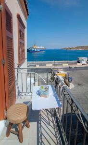 un tavolo e una sedia su un balcone con vista sull'oceano di Ostria a Ermoupoli