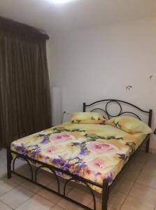 1 cama con edredón de flores en un dormitorio en Smell Sea, en Paralia Katerinis