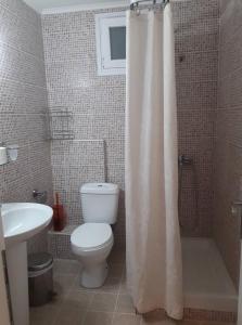 a bathroom with a toilet and a shower curtain at Smell Sea in Paralia Katerinis