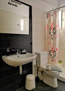bagno con lavandino, servizi igienici e specchio di Ostria a Ermoupoli