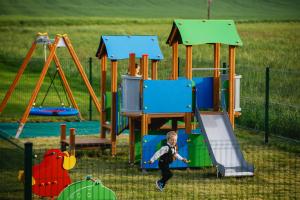 młody chłopiec bawi się na placu zabaw w obiekcie Biała Akacja Resort & Business w mieście Prudnik