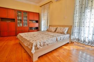 1 dormitorio con 1 cama con suelo de madera y armarios rojos en Pospolita Guest House, en Kutaisi