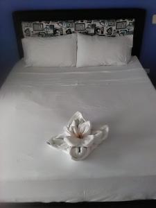 a white bed with a white flower on it at Okawango Hotel in Girardot