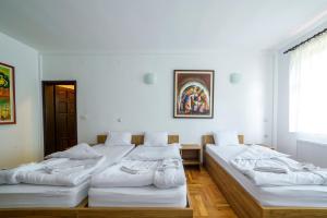 Kriva PalankaHotel Manastir Sv. Joakim Osogovski的白色墙壁的客房内的三张床