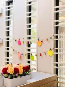 um arranjo de flores numa janela com luzes de Natal em Seri Manjung HomeStay @Spacious Family Home em Seri Manjung