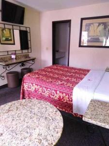 a hotel room with two beds and a table at Hotel Descanso Inn in Tijuana