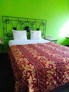 - une chambre dotée d'un lit avec un mur vert dans l'établissement Hotel Descanso Inn, à Tijuana