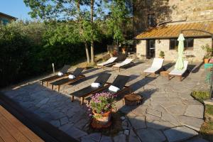 a group of chairs and umbrellas on a patio at Casa Lucia in Chianti in Vagliagli