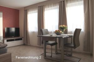 a dining room with a table with chairs and a television at Landhaus Lüdorf in Sinspert