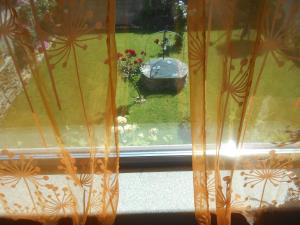 ventana con vistas a un jardín con bañera de aves en XARDÍN DE ESTRELAS *** en Sarria