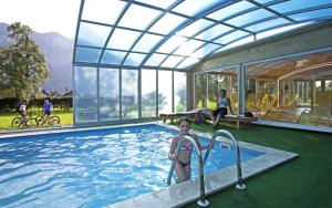 una mujer en una piscina en una casa en Landhotel Agathawirt en Bad Goisern