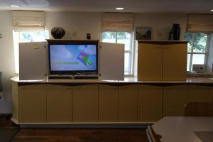 a room with a television on a counter with cabinets at Art, Bed & Breakfast in Velden