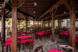 Kriva PalankaHotel Manastir Sv. Joakim Osogovski的一间空餐厅,配有红色的桌椅