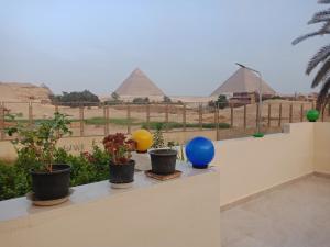 uma vista para as pirâmides a partir de uma varanda com plantas em shahbor 2pyramids view no Cairo